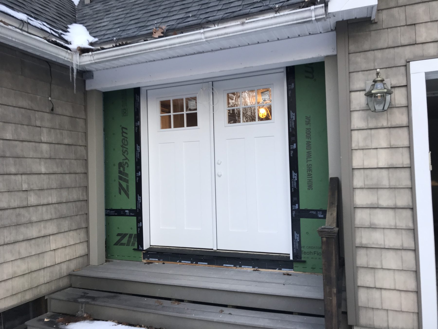 New white double entry doors with ZIP System sheathing and snow on the roof