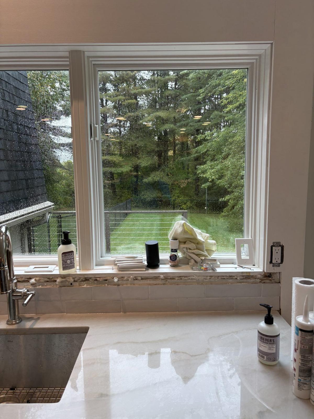 Kitchen window over a stone sink looking into the woods