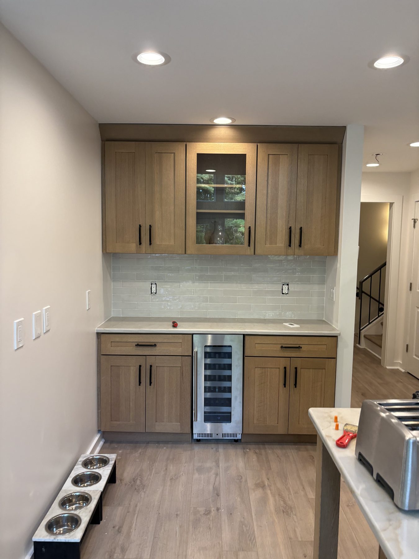 Oak wet bar with glass-front cabinet and stainless wine refrigerator